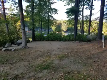 View of Site 123 nestled among tall pines with filtered views of Swains Lake